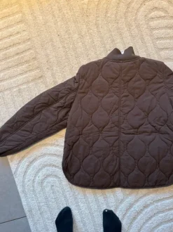 Kevyt tikkitakki kultaisilla yksityiskohdilla