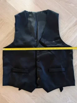 Liivi, solmio, rusetti, henkselit, taskukello ja viikset