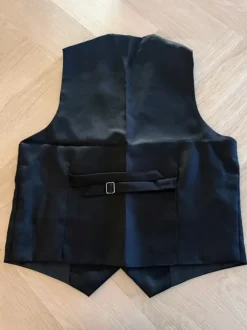 Liivi, solmio, rusetti, henkselit, taskukello ja viikset