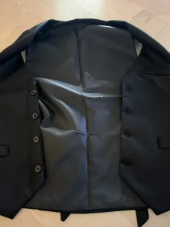 Liivi, solmio, rusetti, henkselit, taskukello ja viikset