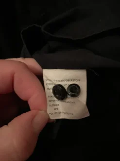 Musta kauluspaita rintataskulla