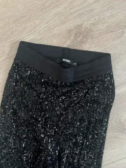 Mustat paljettihousut levenevillä lahkeilla