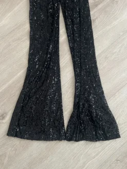 Mustat paljettihousut levenevillä lahkeilla